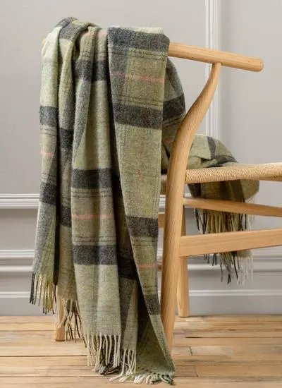 Green plaid wool throw draped across wooden chair